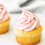 Creamy raspberry frosting swirled on a cupcake, made with fresh raspberries and jam.