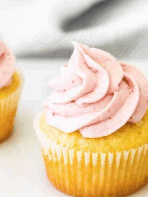 Creamy raspberry frosting swirled on a cupcake, made with fresh raspberries and jam.