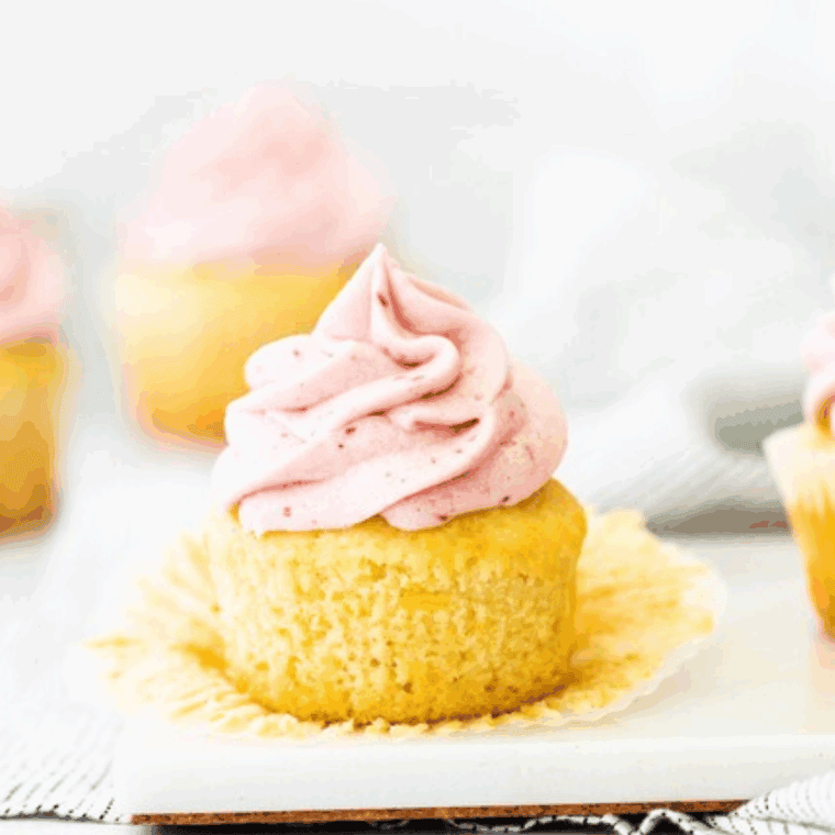 Creamy raspberry frosting made with fresh raspberries and jam on a cupcake.