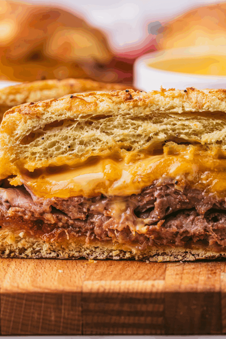 Bowl of homemade Arby’s Red Ranch Sauce surrounded by curly fries and a roast beef sandwich.