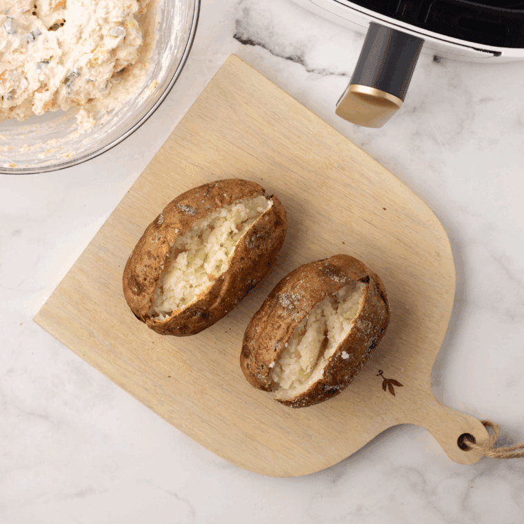 Baked potato cut in half lengthwise, ready to be stuffed.