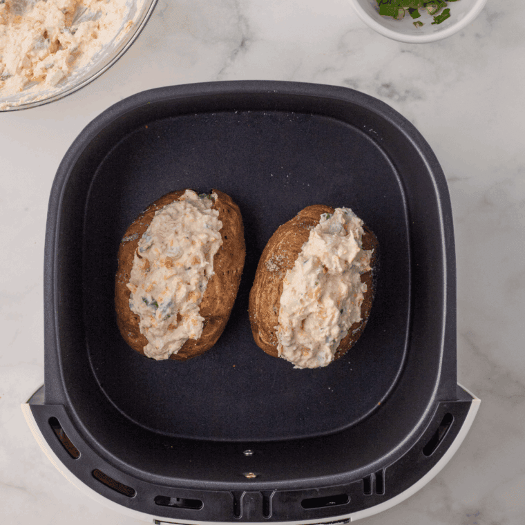 Stuffed potatoes in the air fryer, cooking until the cheese is melted and bubbly.