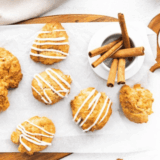 Golden brown sourdough apple fritters topped with glaze on a wire rack