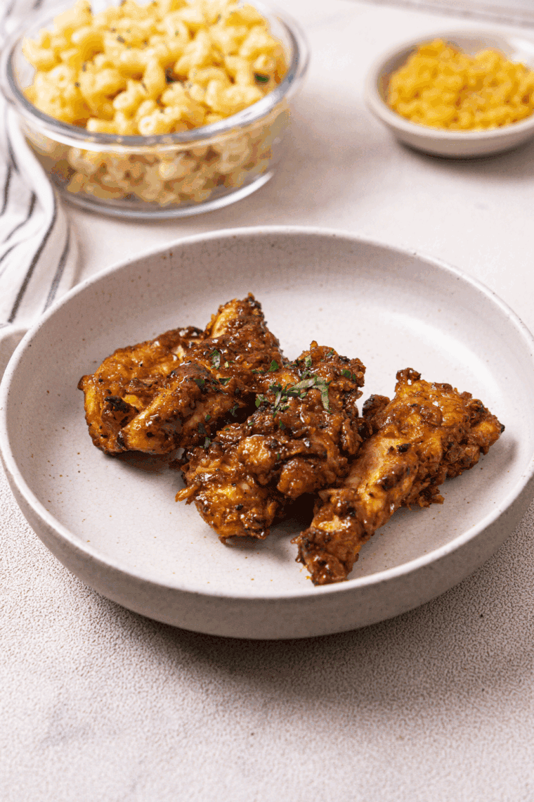 Crispy hot honey chicken tenders coated in sweet and spicy Wingstop-style rub served on a plate with dipping sauce.