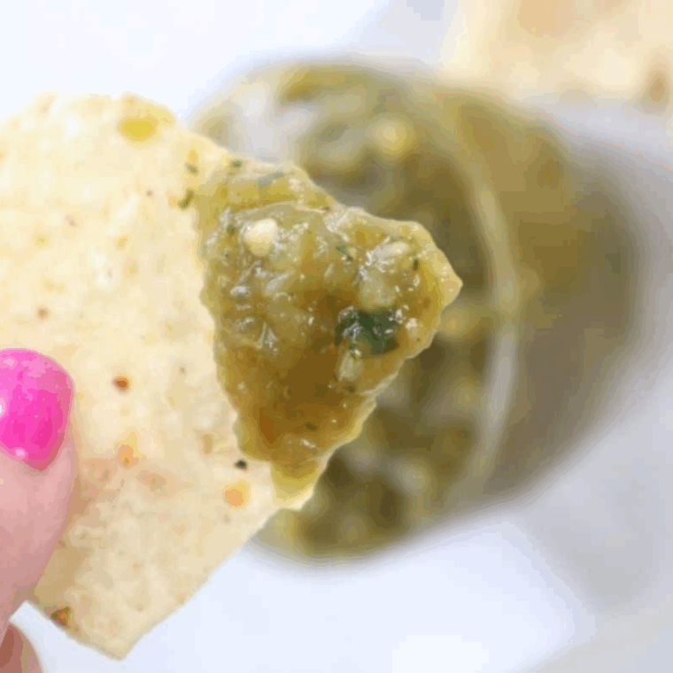 Bowl of homemade Copycat Abuelo’s Fresh Tomatillo Salsa with tortilla chips on the side.