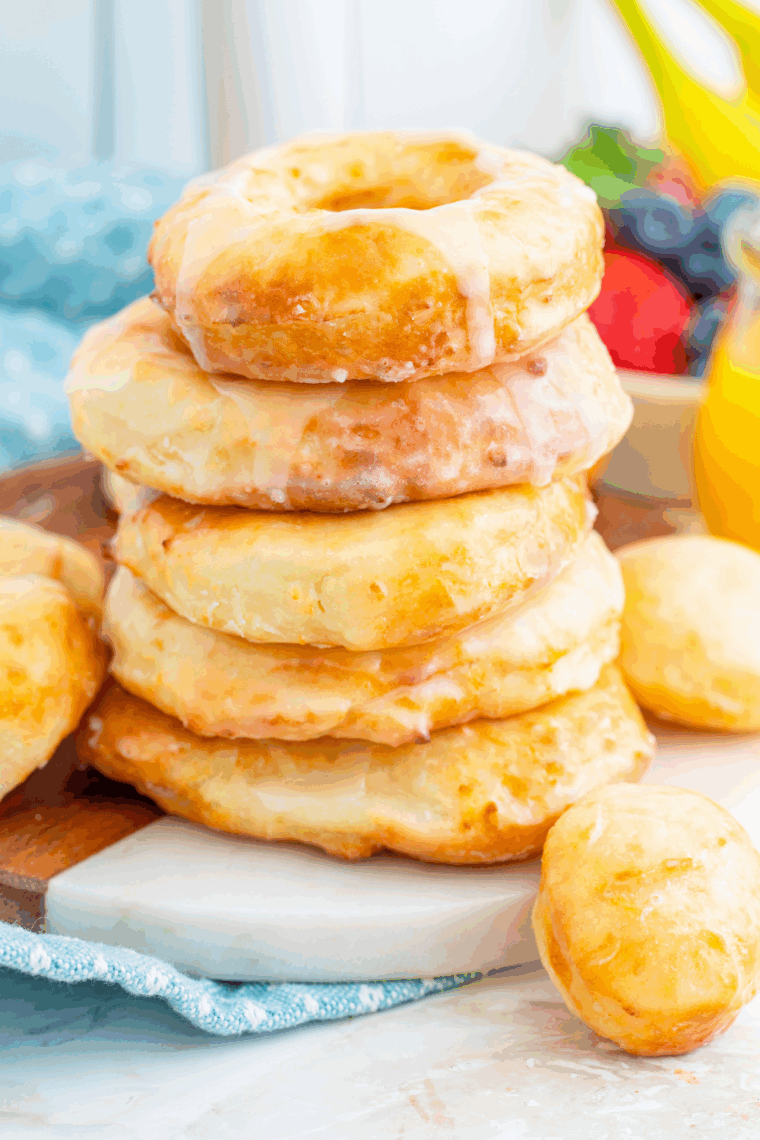 Golden air fryer Greek yogurt donuts cooling on a rack with a light glaze drizzle.
