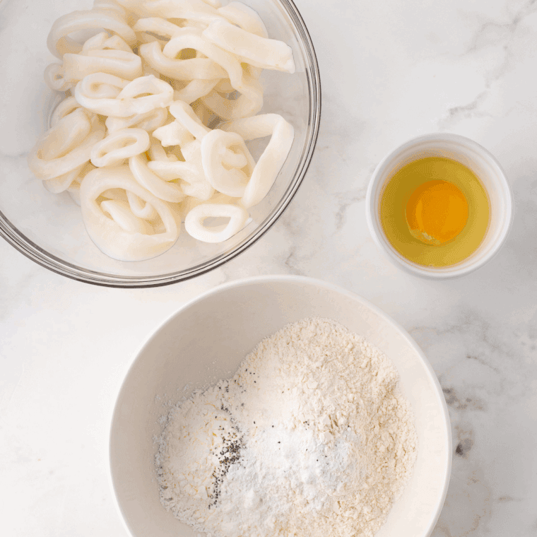 Rinsing and patting dry fresh calamari rings to ensure crispy coating.