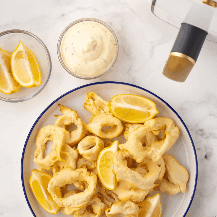 Hibachi-style Benihana calamari cooked at home, garnished with green onions and lemon wedges.