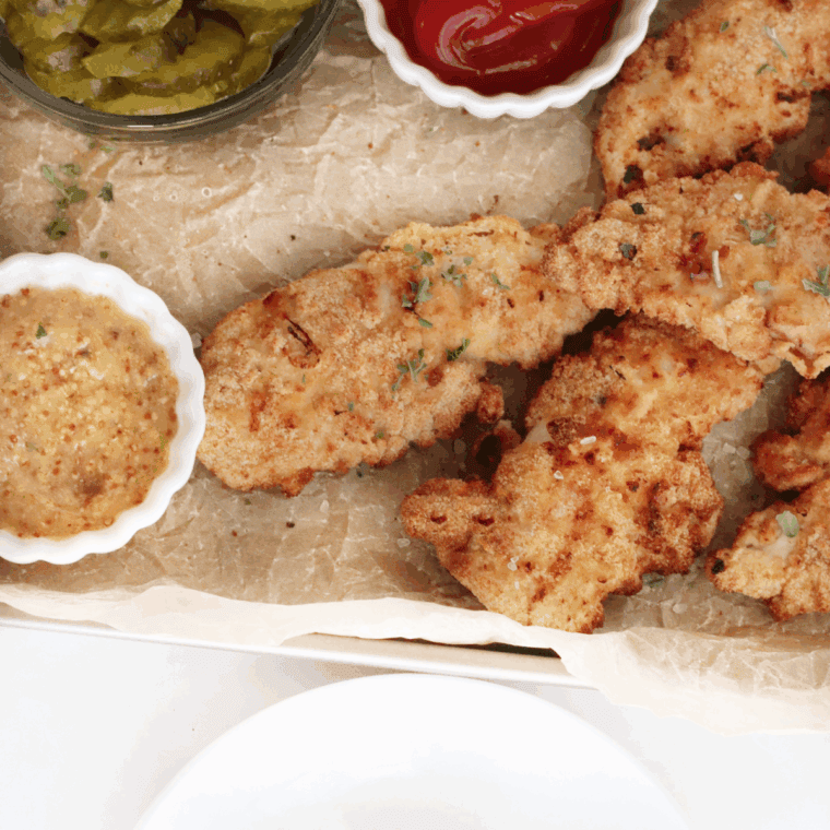 Plated golden color fried Bob Evan’s hand-breaded chicken tenders with dipping sauce.