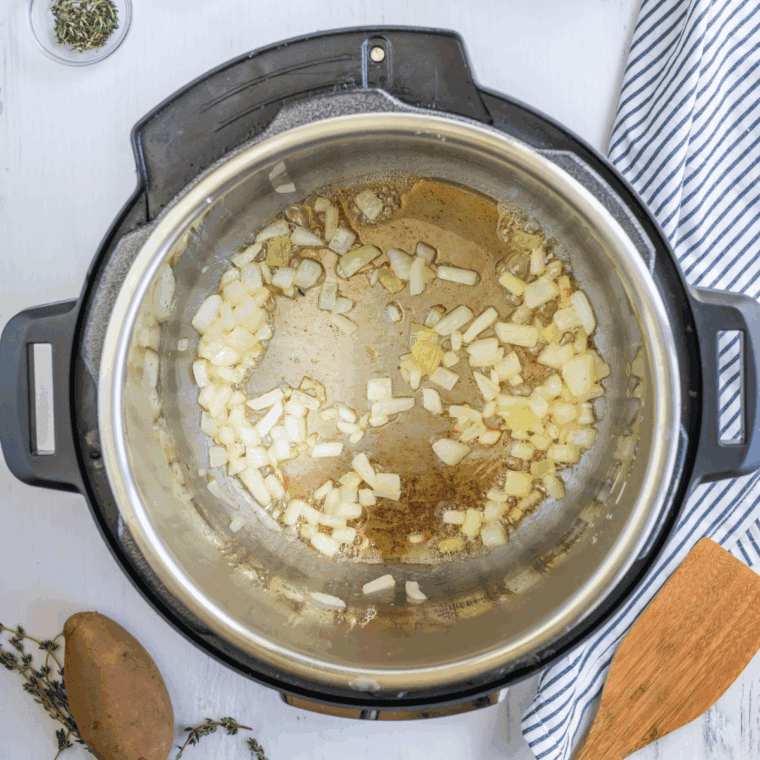 Sauté the aromatics: Diced onions, celery, and minced garlic cooking in melted butter in the Instant Pot.