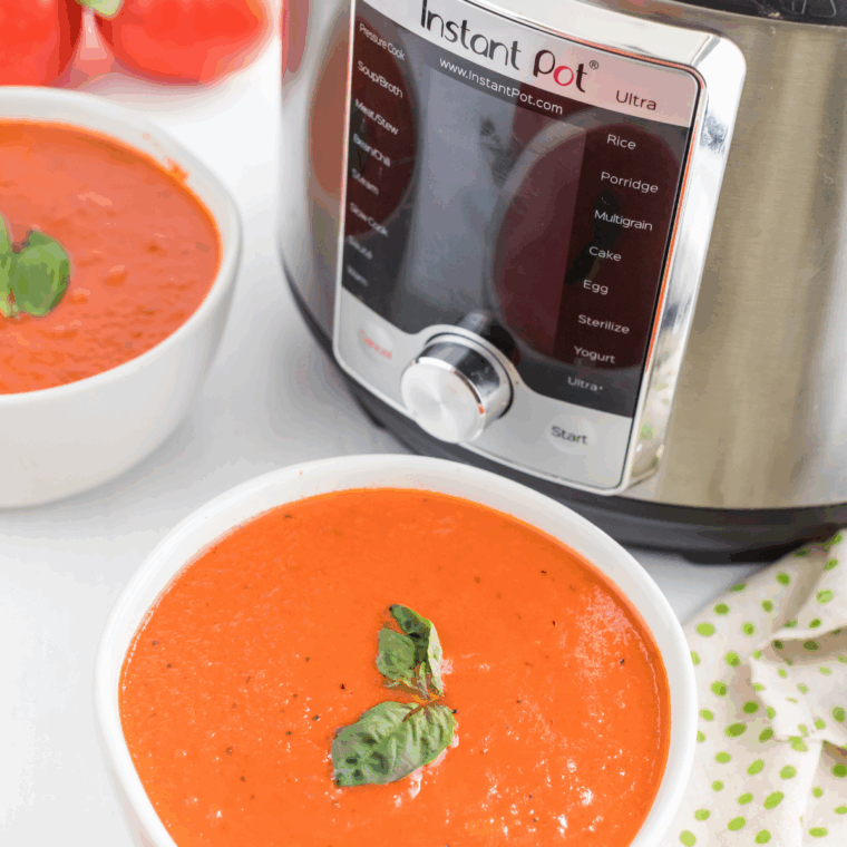 Homemade tomato soup in a bowl with fresh basil garnish