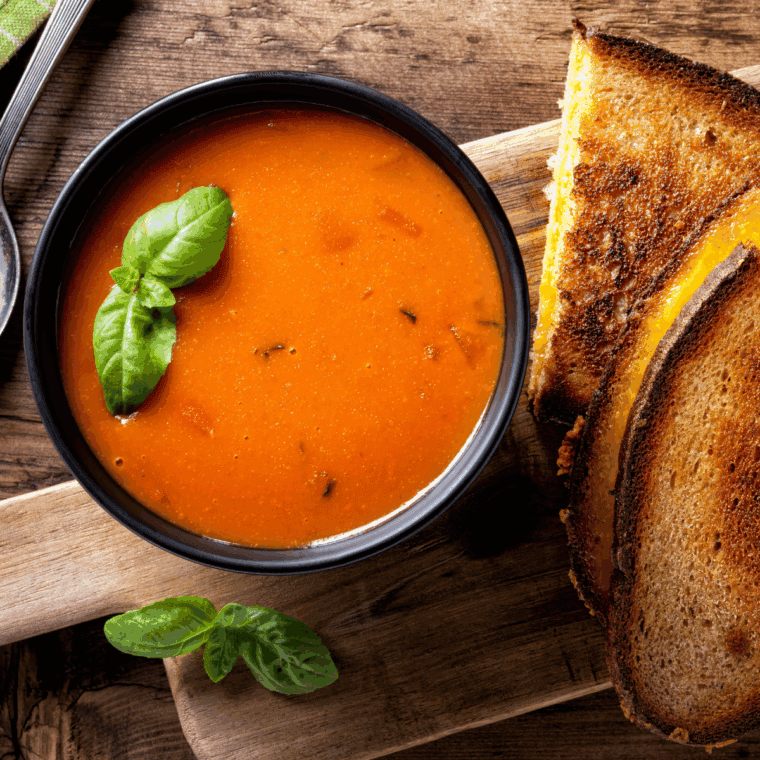 Homemade tomato soup in a bowl with fresh basil garnish