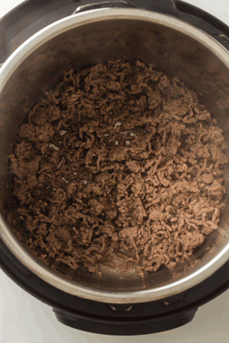 Ground beef browning in Instant Pot, ready to be mixed.