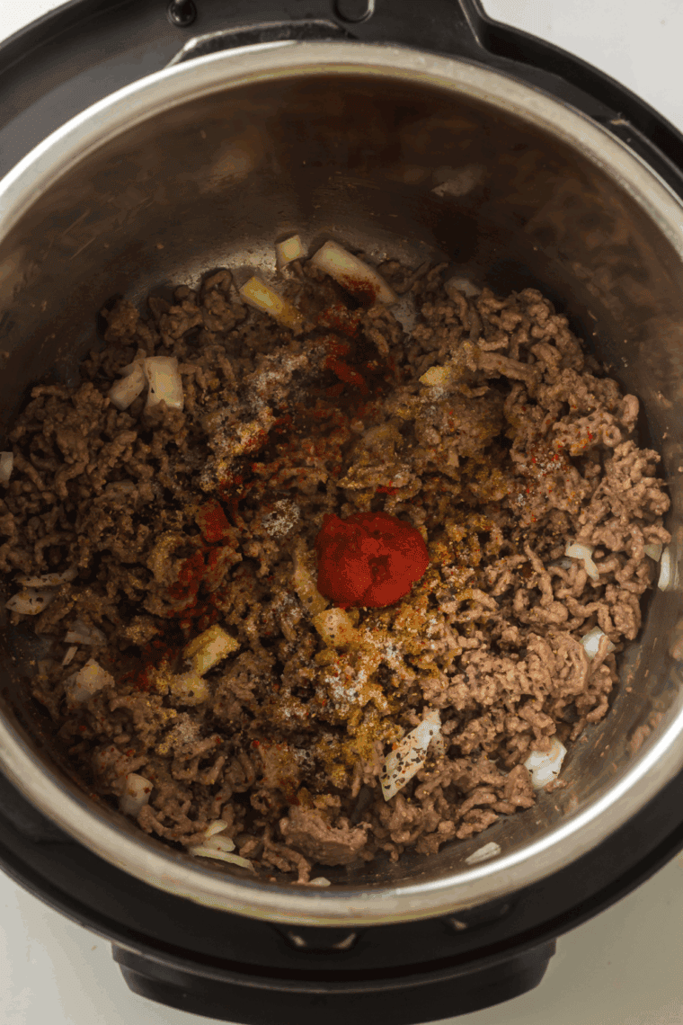 Adding mushrooms, beans, tomato soup, diced tomatoes, and spices.