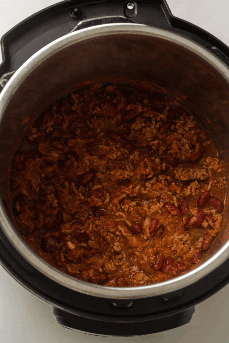 Finished chili served in a bowl with optional toppings.