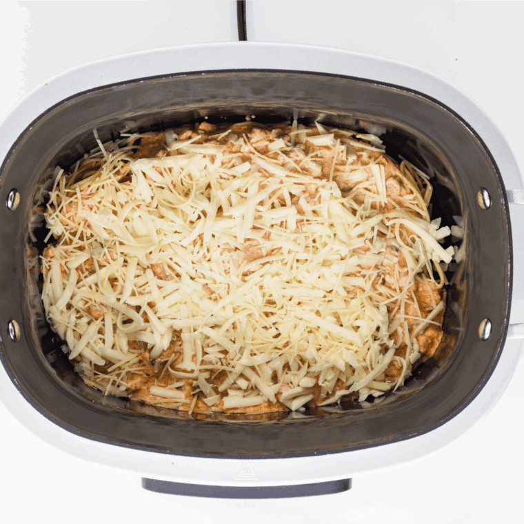 Spreading a mixture of cream cheese and ricotta over pasta, then sprinkling with mozzarella and parmesan, repeating layers until all ingredients are used.