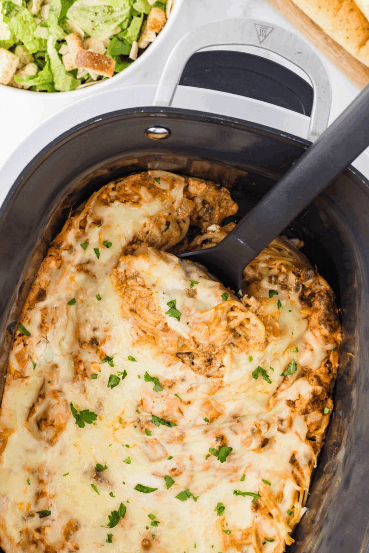 Covered crockpot cooking pasta on LOW or HIGH until tender and bubbly, garnished with extra parmesan or fresh basil, ready to serve.