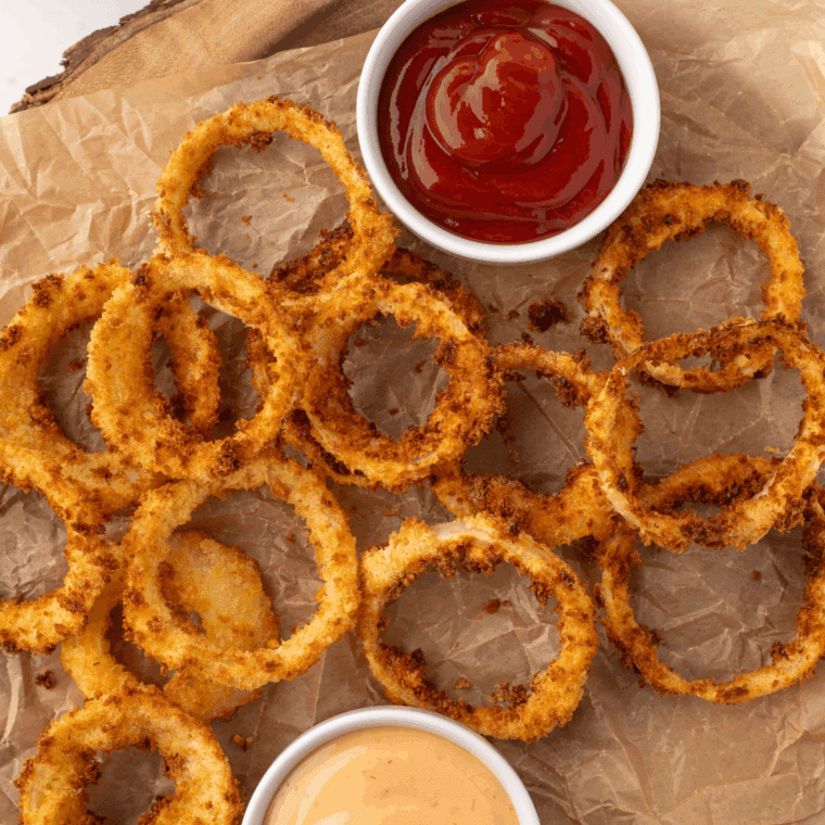 Golden crispy Dairy Queen-style onion rings served on a plate with dipping sauce
