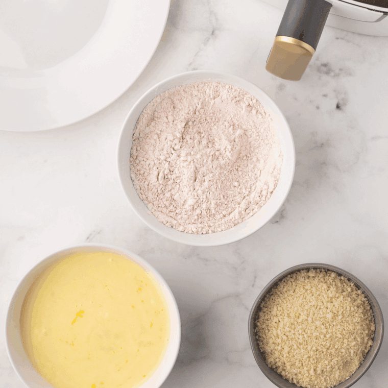 Whisking flour, baking powder, salt, pepper, and buttermilk into smooth batter.