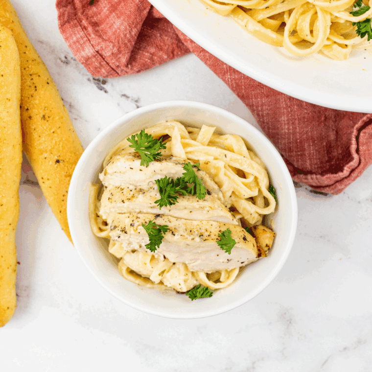 Homemade Domino’s-style chicken Alfredo pasta with creamy sauce, grilled chicken, and Parmesan cheese, garnished with fresh parsley.