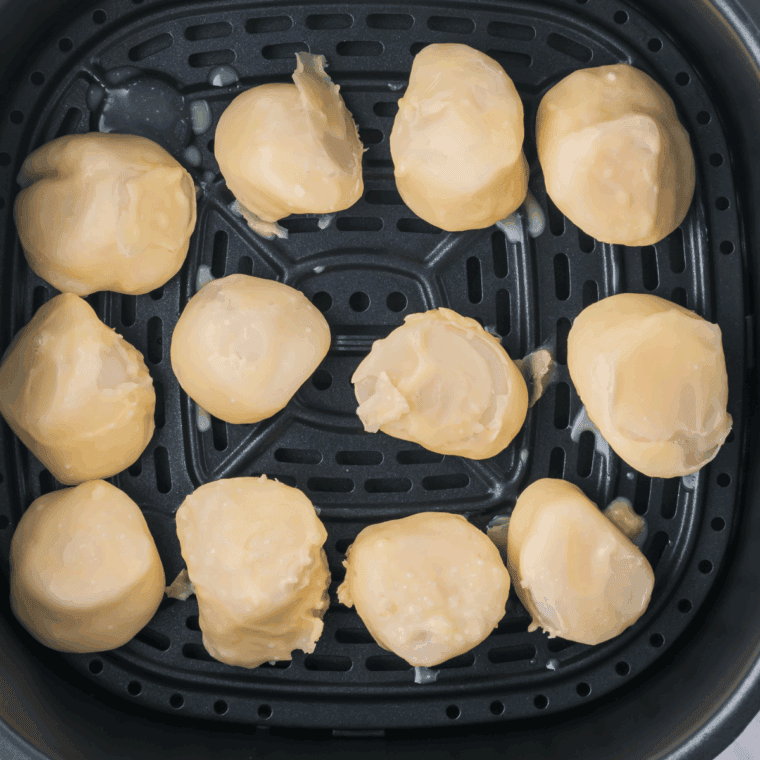 Seared scallops cooking in a skillet with garlic and fresh lemon juice, golden brown and perfectly cooked.