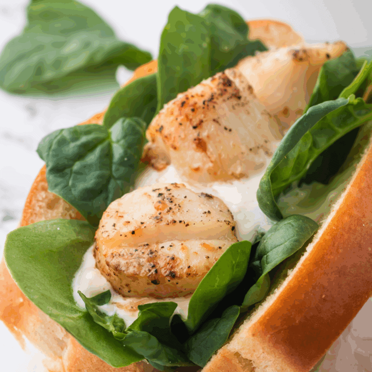 Golden seared Frontier scallops served with lemon wedges and fresh herbs.