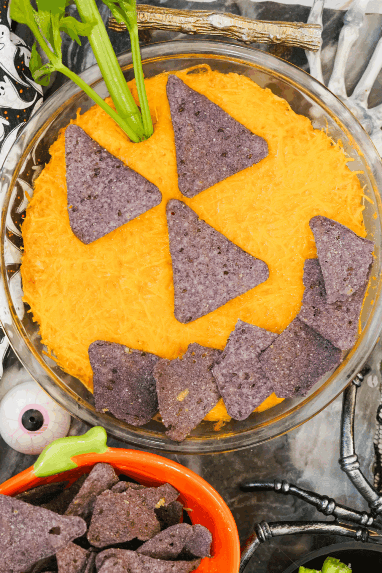 Halloween Boo-falo wings dipped in baking, decorated with celery “stems” and tortilla chips pumpkin faces, ready to serve.