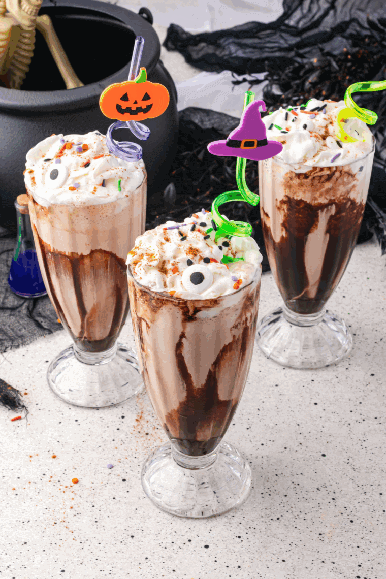 Festive Halloween milkshake in a tall glass with candy eyes.