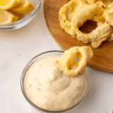 Homemade Ina Galton tartar sauce in a bowl with lemon and dill garnish.