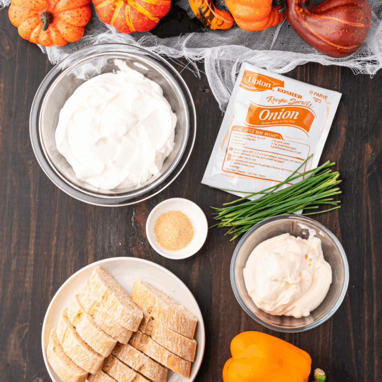 Ingredients needed for Jack-O'-Lantern Onion Dip Recipe on kitchen table.