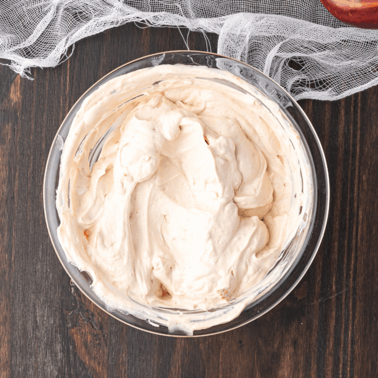 Mixing sour cream, mayonnaise, onion soup mix, and garlic powder in a bowl until smooth.