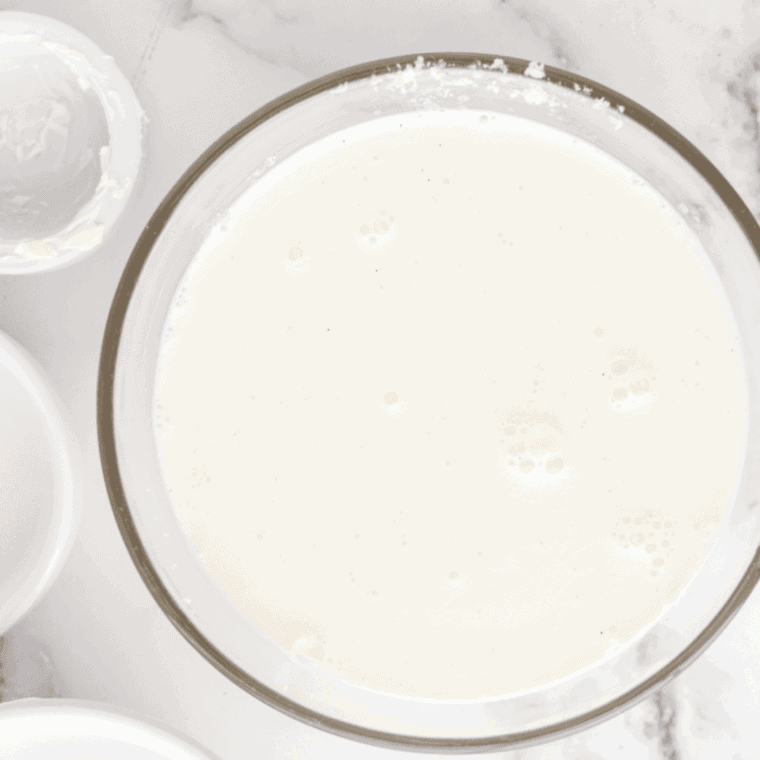 Mixing bowl with milk, cream, sugar, and vanilla whisked smooth.