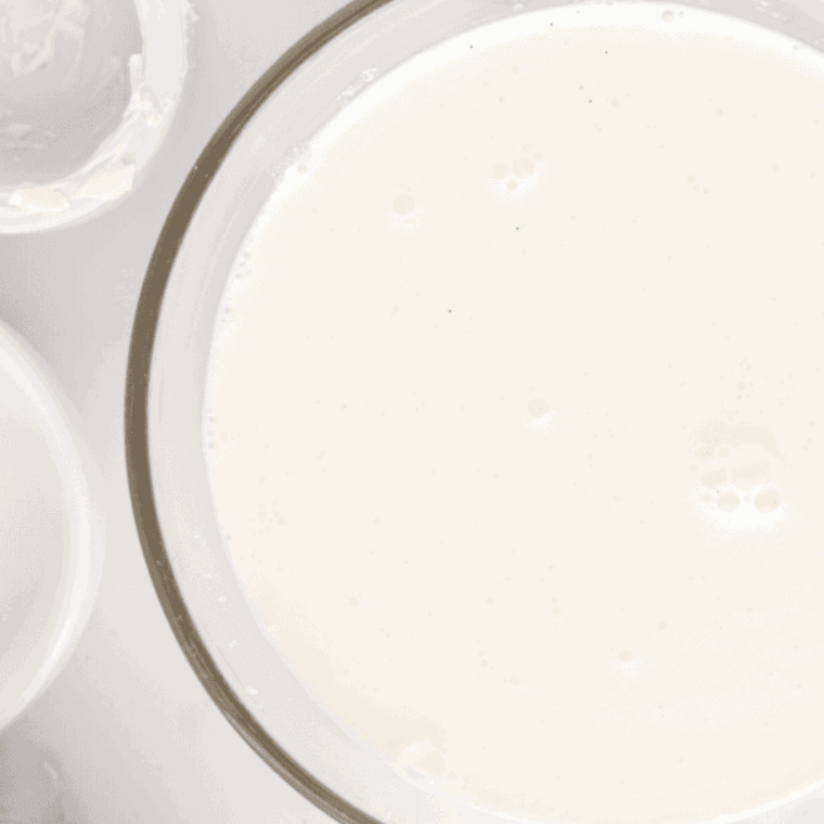 Whisking heavy cream, milk, sugar, and vanilla extract in a large bowl until fully combined for the ice cream base.