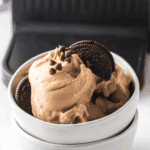 Bowl of Ninja Creami Copycat Blue Bell Cookies ‘n Cream ice cream with chocolate cookie pieces.
