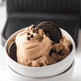Bowl of Ninja Creami Copycat Blue Bell Cookies ‘n Cream ice cream with chocolate cookie pieces.