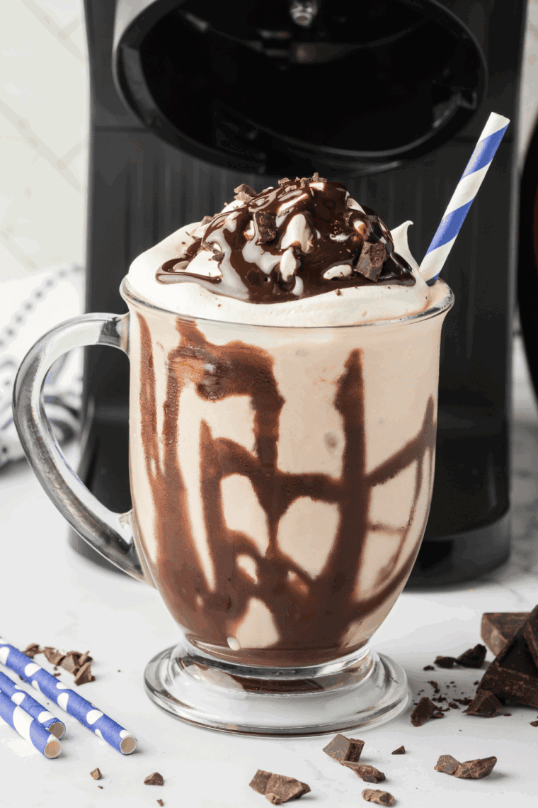 Homemade Ninja Creami Dairy Queen Mocha MooLatte in a tall glass with whipped cream and chocolate drizzle