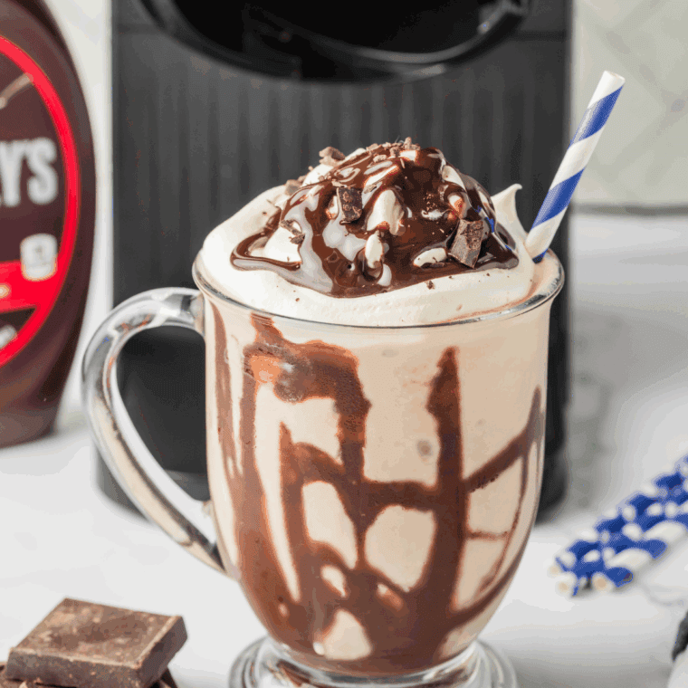 Ninja Creami Dairy Queen Mocha MooLatte in a tall glass topped with whipped cream and chocolate drizzle