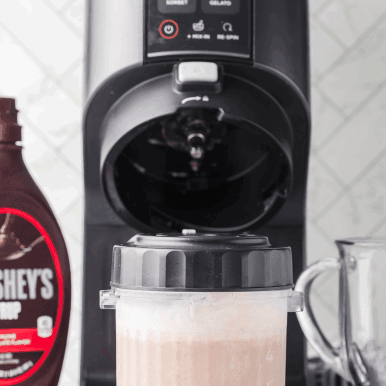 Pouring mocha base mixture into a Ninja Creami pint container before freezing.