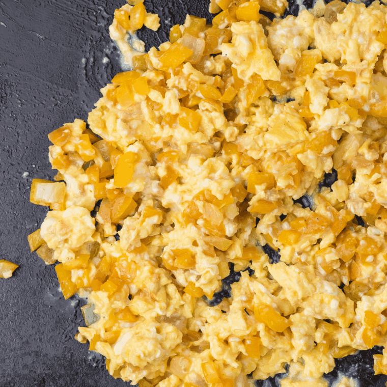 Scrambled eggs cooking in a skillet, soft and fluffy, ready for breakfast quesadillas.