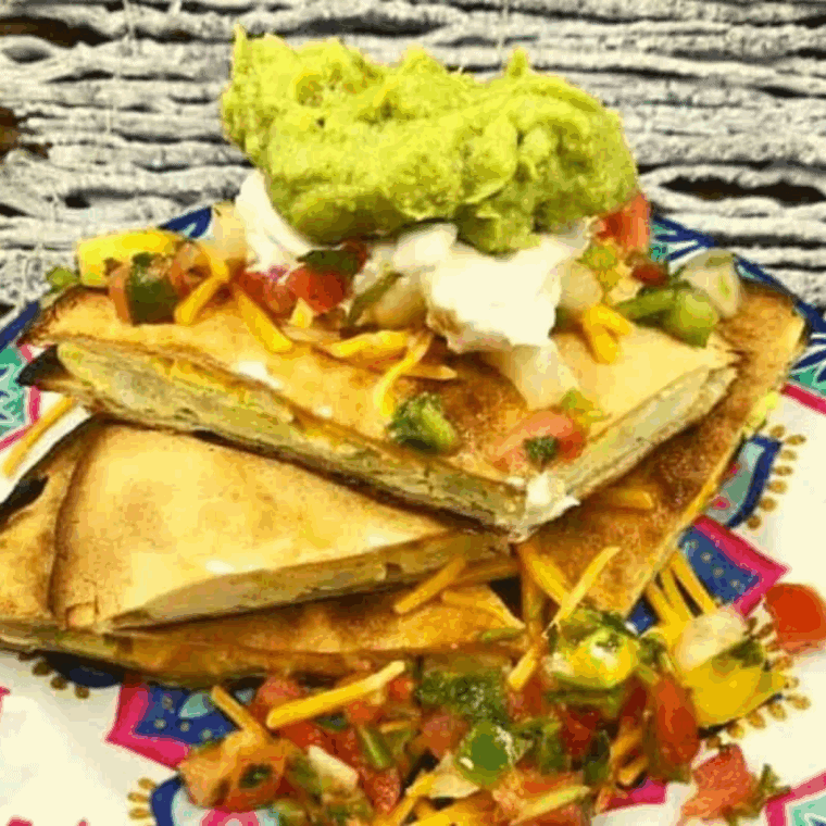 Homemade Taco Bell-style breakfast quesadilla with melted cheese, scrambled eggs, and breakfast meat, sliced and ready to serve.
