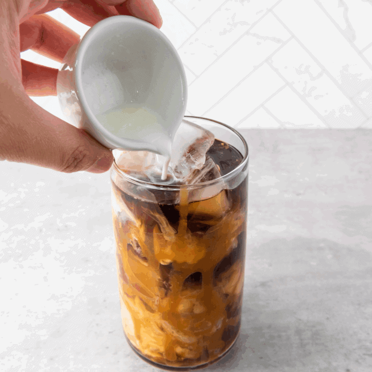 Homemade Tim Hortons iced coffee served in a glass with straw.