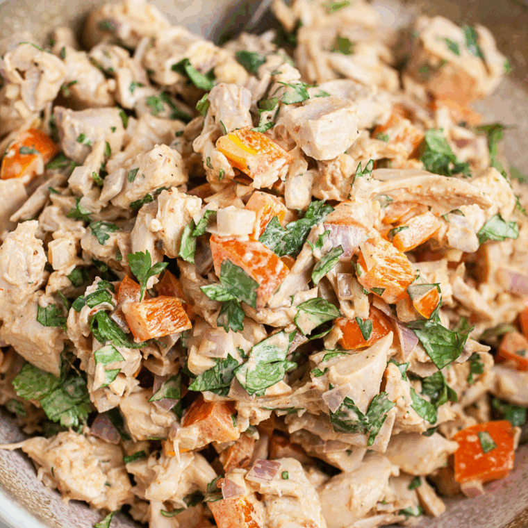 Bowl of creamy Waldorf-Astoria Thousand Island dressing with a spoon, ready to serve on salads or sandwiches.