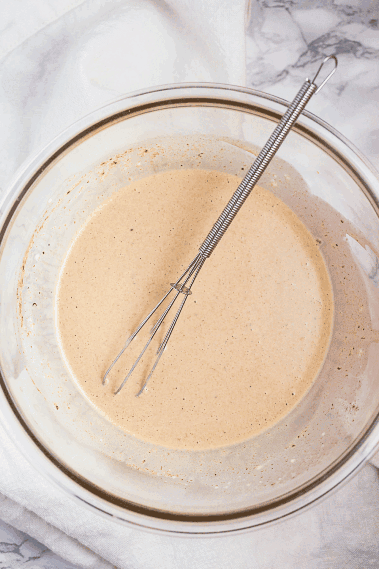 Bowl of creamy Waldorf-Astoria Thousand Island dressing with a spoon, ready to serve on salads or sandwiches.