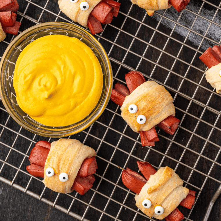 Easy Halloween Spider Hot Dogs with crescent roll dough, candy eyes, and spider leg details ready to serve.