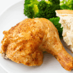 Golden roasted Barefoot Contessa Cornish Hen served on a platter with herbs.
