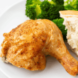 Golden roasted Barefoot Contessa Cornish Hen served on a platter with herbs.