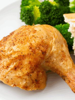 Golden roasted Barefoot Contessa Cornish Hen served on a platter with herbs.