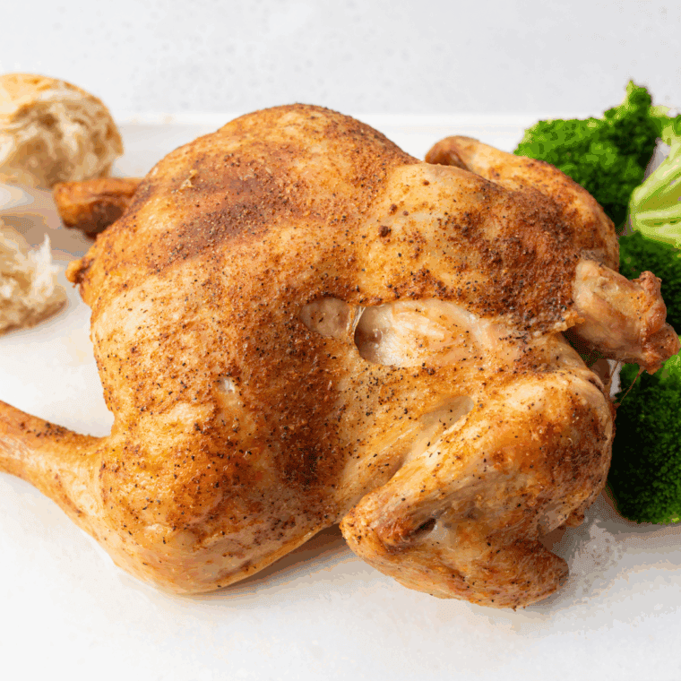 Golden roasted Cornish hens resting on a tray, sprinkled with fleur de sel, ready to serve.