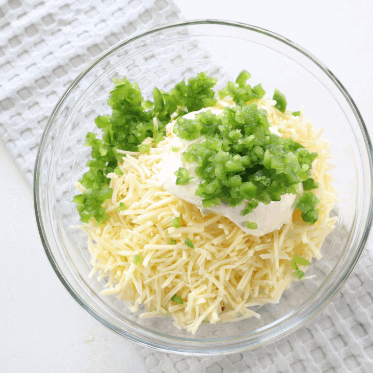 Mixing diced jalapeños with cream cheese and shredded cheeses for smooth filling.