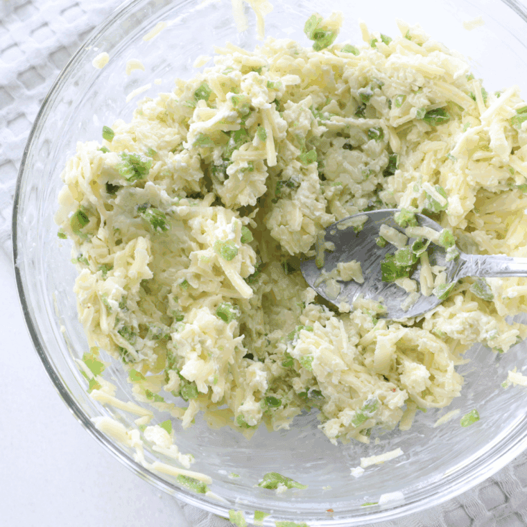 Combining jalapeños, cream cheese, cheddar, Monterey Jack, and seasonings into smooth filling.